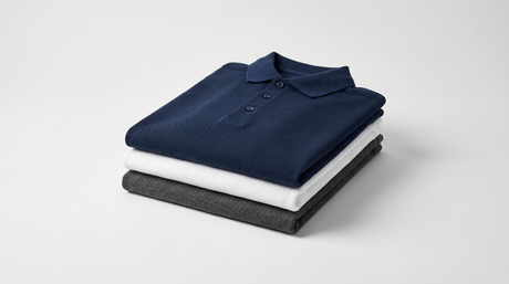Custom embroidered polo shirts stacked - premium B2B uniforms from Arklavo in navy, white, and charcoal cotton pique