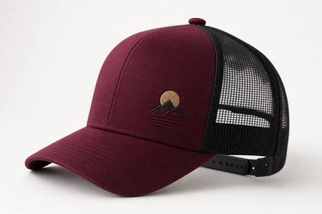 Deep mulberry trucker hat at an angle showing the stiff foam front panel, black mesh back panels, and snapback closure