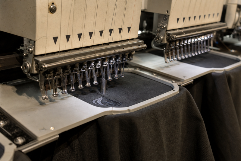 An embroidery machine stitching a logo onto a shirt