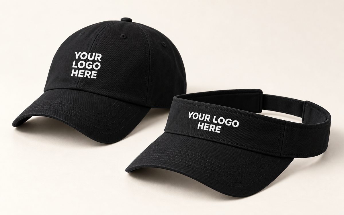Black performance cap and open-top visor with white YOUR LOGO HERE embroidery on their front panels.