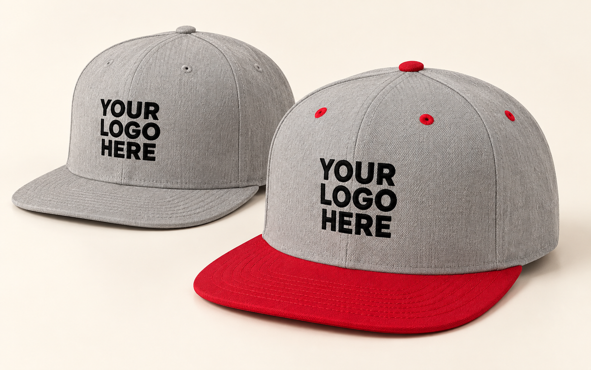 Grey snapback and grey snapback with red brim, both with black YOUR LOGO HERE front embroidery.
