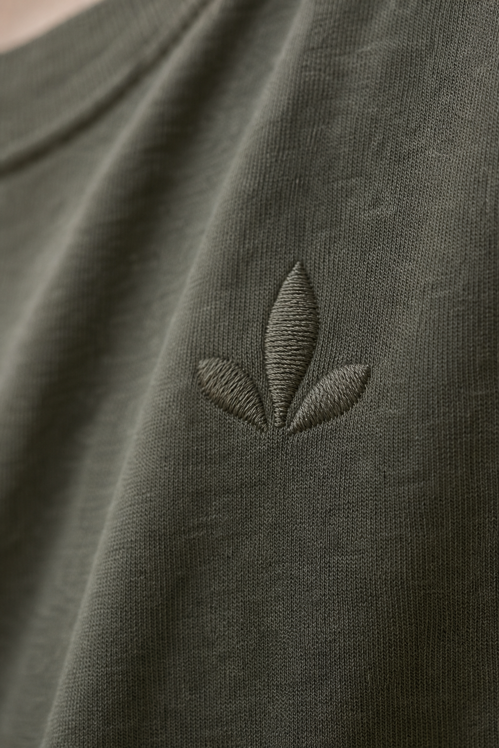Close-up of an embroidered emblem on cotton t-shirt fabric