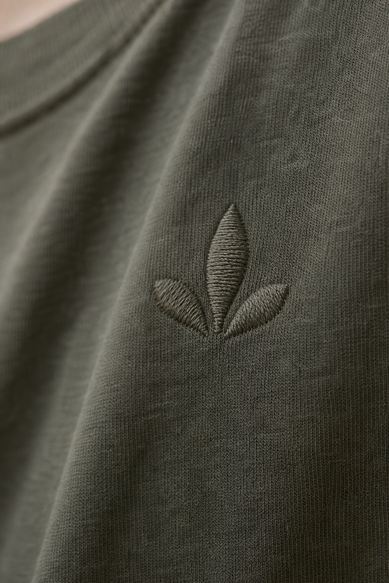 Close-up of an embroidered emblem on cotton t-shirt fabric