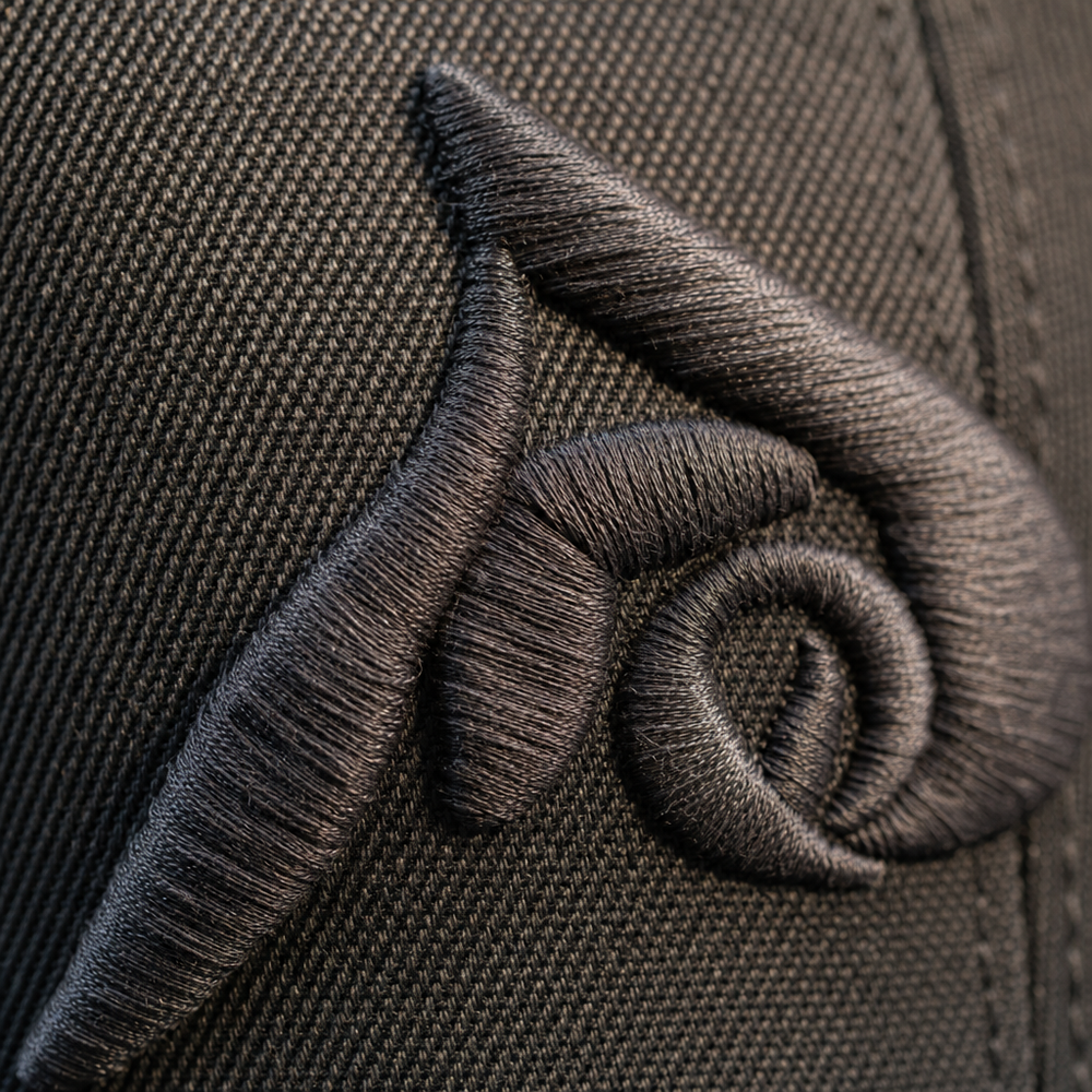 Close-up of an embroidered logo stitched into a cap
