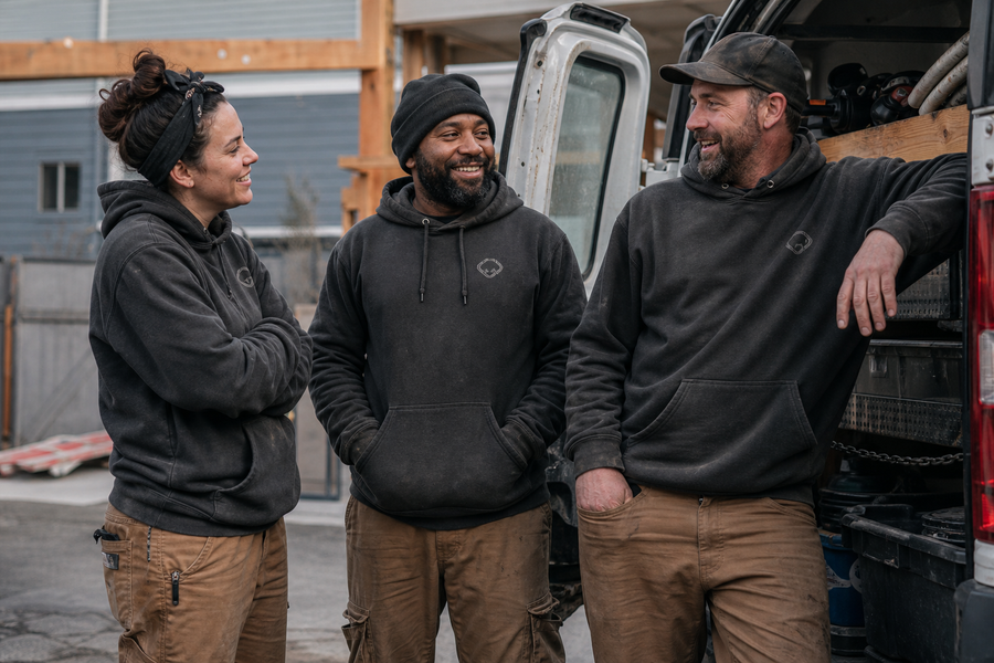 A trades crew in matching custom embroidered hoodies at a job site