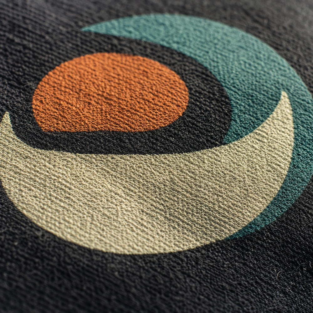 Close-up of an embroidered logo on a screen-printed t-shirt